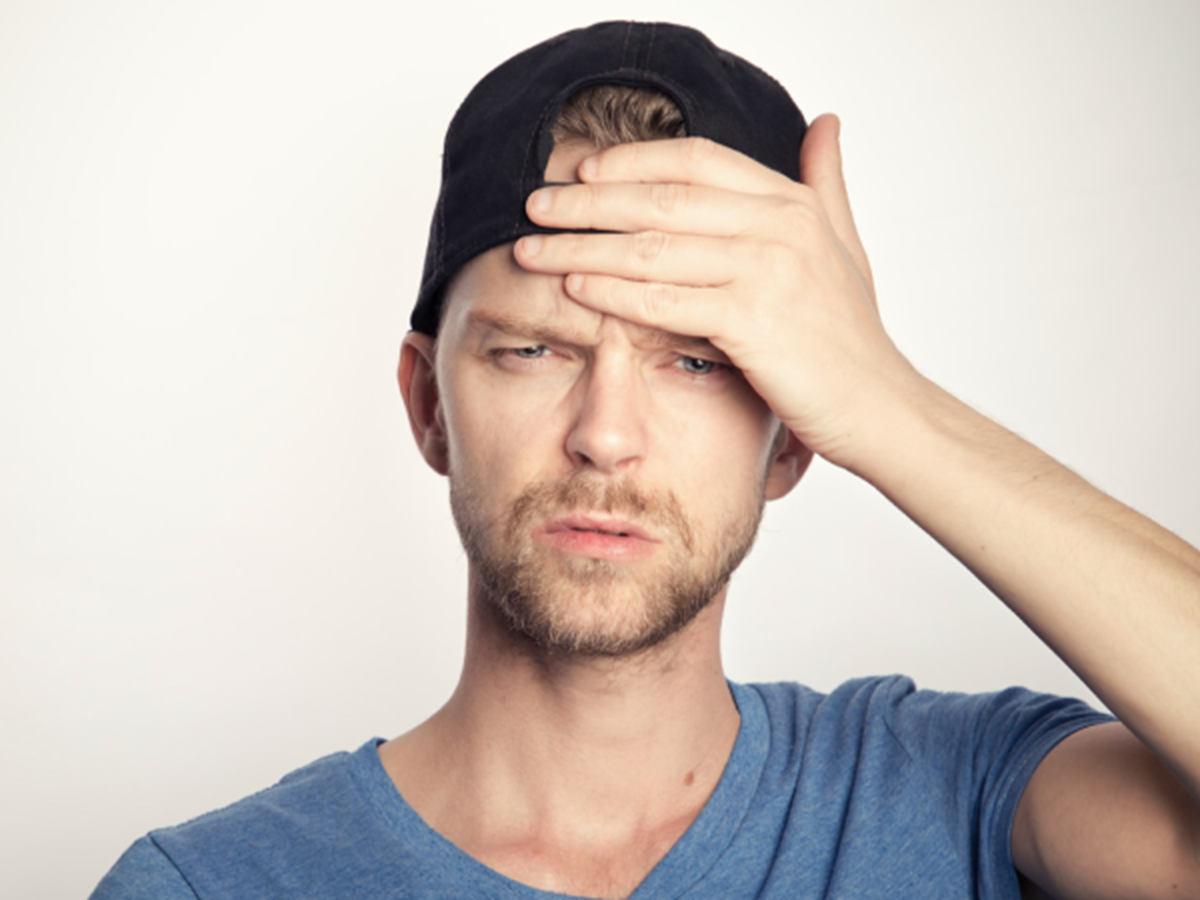 a guy putting his hand on his head upset 