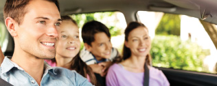 a happy young family smiling in a car 