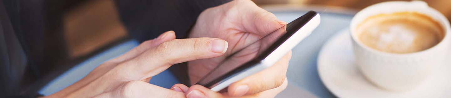 a person having coffee scrolling on their phone