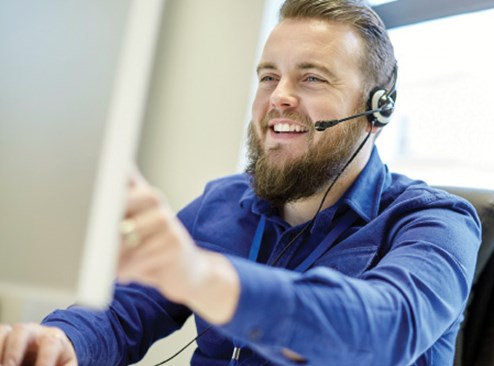 a businessman talking on a headset smiling 