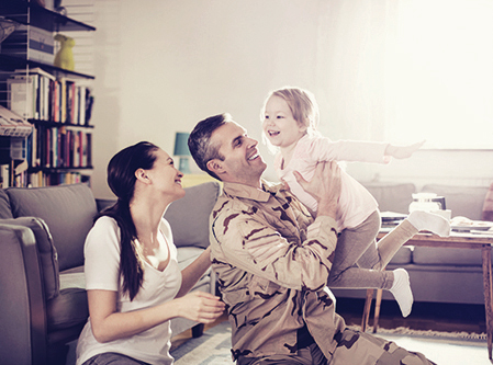 a young family sitting in the lounge room playing 