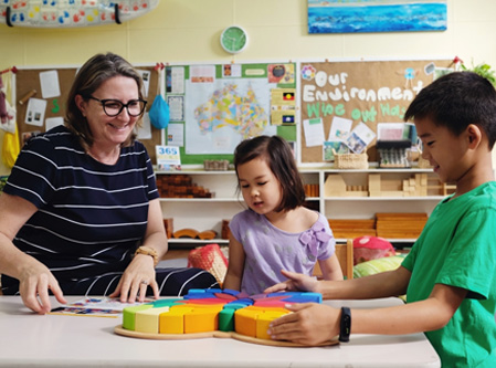 a primary school teacher with two of her young students