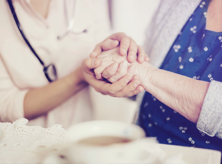 a nurse holding the hand of an older women